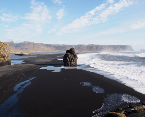 beautiful black sand with a huge rock